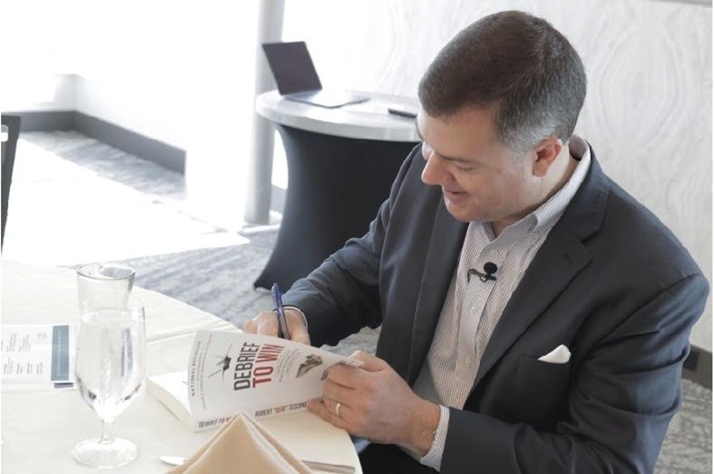 Robert Cujo Teschner signing copies of Debrief to Win